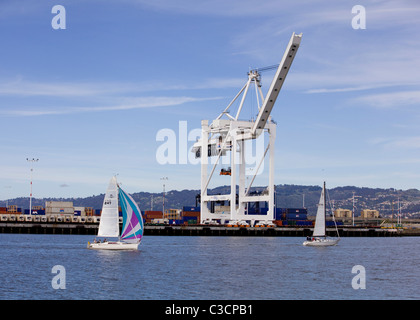 Barche a vela e il Gantry cranes - Porto di Oakland, California USA Foto Stock