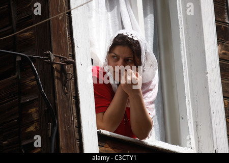 Un locale Turchia donna guardando fuori dalla sua finestra. Foto Stock