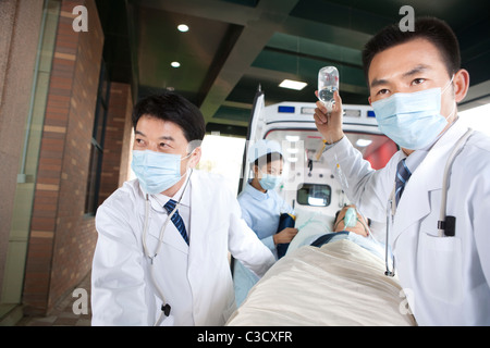 I medici lo spostamento di un paziente da un'ambulanza Foto Stock