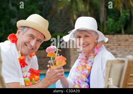 Felice coppia senior di bere cocktail e tostatura di ciascun altro Foto Stock