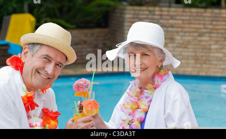 Felice coppia senior di bere cocktail e tostatura di ciascun altro Foto Stock