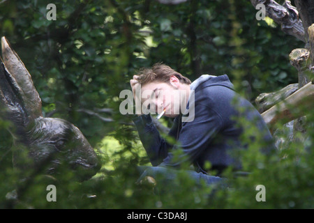 Robert Pattinson fuma una sigaretta sul set del suo nuovo film "Ricordami" durante la ripresa sulla posizione in un parco nel cuore di Manhattan. Foto Stock