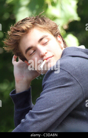 Robert Pattinson fuma una sigaretta sul set del suo nuovo film "Ricordami" durante la ripresa sulla posizione in un parco nel cuore di Manhattan. Foto Stock