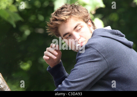 Robert Pattinson fuma una sigaretta sul set del suo nuovo film "Ricordami" durante la ripresa sulla posizione in un parco nel cuore di Manhattan. Foto Stock