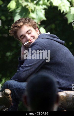 Robert Pattinson fuma una sigaretta sul set del suo nuovo film "Ricordami" durante la ripresa sulla posizione in un parco nel cuore di Manhattan. Foto Stock