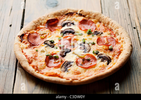 Salsiccia per pizza e mushrooom pizza sul tavolo rustico Foto Stock