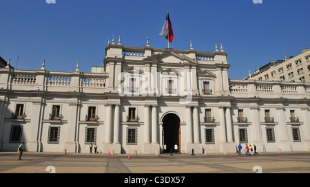 Blue sky di fronte il Palazzo Presidenziale di La Moneda, Bandiera cilena su ingresso e turisti in Piazza della Costituzione, Santiago del Cile Foto Stock