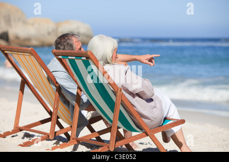 Coppia in pensione seduti su sedie a sdraio Foto Stock