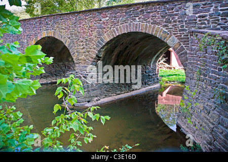 Immagine hdr di riflessioni in Bull Run Creek attraverso gli archi del ponte storico in pietra sul Manassas National Battlefield. Foto Stock