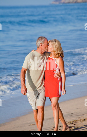 Coppia di mezza età costeggiata sulla spiaggia Foto Stock