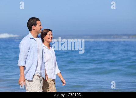 Paio di camminare sulla spiaggia sotto il sole Foto Stock