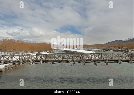 Il vecchio ponte di legno di fronte fiume Indo in Ladak, India Foto Stock