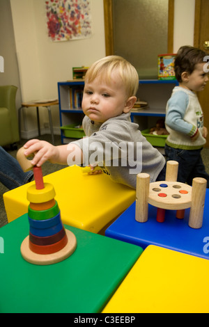 Scuola materna bambino sviluppa mano coordinazione occhio attraverso la riproduzione con tipo puzzle giocattoli. Foto Stock