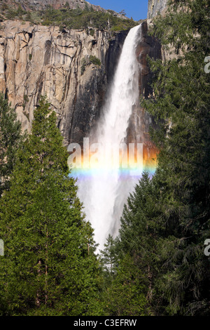 Un arcobaleno forme nella nebbia alla base di Bridalveil rientra nel Parco Nazionale di Yosemite. Foto Stock