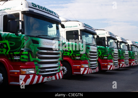 Fila di unità motrice Eddie Stobart Scania HGV R440 parcheggiate; autocarri rimorchi e container a autocarri arrestati; Logo e livrea veicoli da trasporto AEC Scania 440. Foto Stock