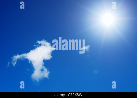 Sun splendenti in un cielo blu accanto a little white cloud Foto Stock