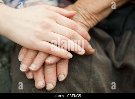 Vecchi e giovani mani. Le mani della vecchia donna - 84 anni coperti con giovani mani Foto Stock