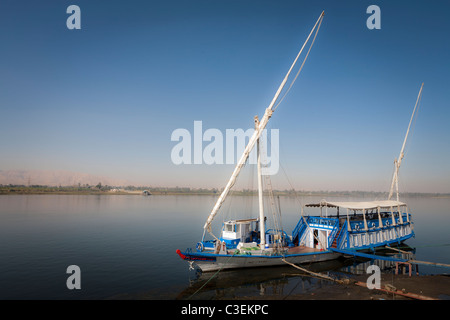 Un dahabiya ormeggiato sulle rive del fiume Nilo in acque calme, Egitto Foto Stock