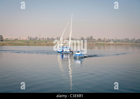Un dahabiya trainato da piccole imbarcazioni sul fiume Nilo in acque calme, Egitto, Africa Foto Stock