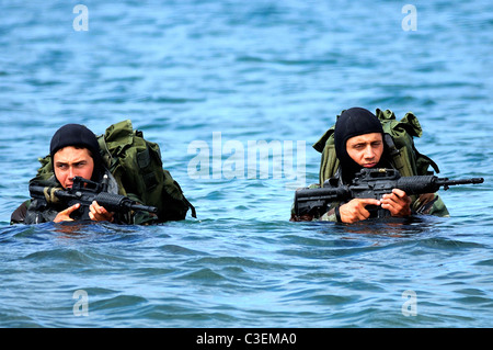 US Navy SEAL ai membri del team di wade a terra sull isola di San Clemente durante un oltre la spiaggia di esercizio. Foto Stock