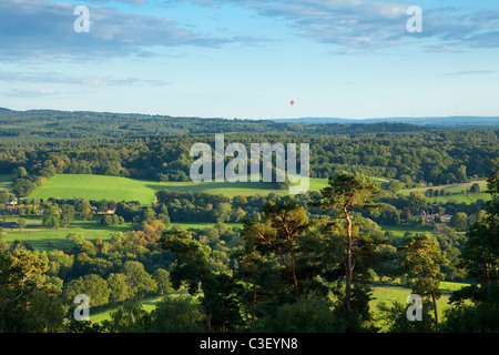 Vista da St Martha's chiesa sopra le colline del Surrey, serata estiva, mongolfiera in distanza, Surrey, Inghilterra Foto Stock