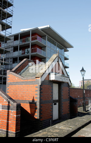 Vittoriano di un edificio di mattoni rossi sulle banchine nella città di Bristol, affiancato da un moderno alto edificio costruzioni Foto Stock