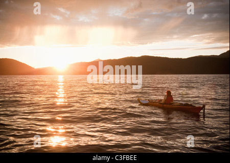 Donna ispanica kayak sul lago Foto Stock