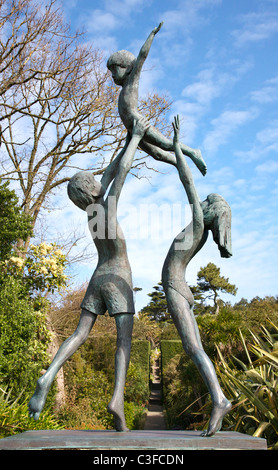 La scultura in bronzo di Tresco bambini cercando la Abbey Gardens fino faro a piedi la statua del Nettuno Foto Stock