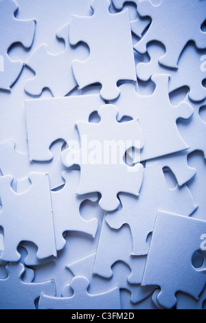 Disposti in modo casuale puzzle pezzi con il focus sottilmente su un pezzo. Foto Stock