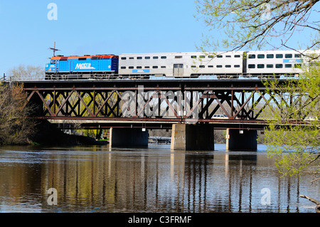Metra treno dei pendolari fuori di Chicago che attraversano il fiume Fox ruggine sul ponte. Foto Stock