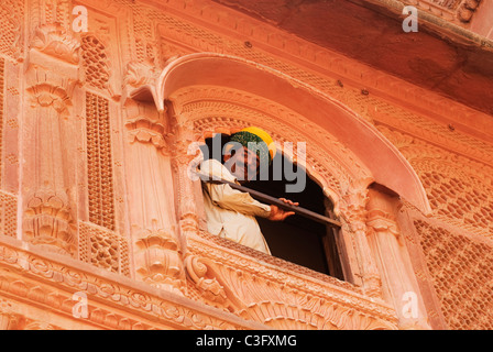 Basso angolo di visione di un turista nella finestra di un fortilizio, Meherangarh Fort, Jodhpur, Rajasthan, India Foto Stock