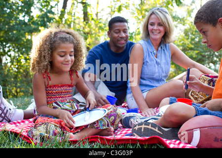 Interracial famiglia avente picnic Foto Stock