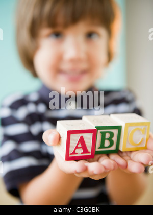 Ispanico boy holding blocchi alfabeto Foto Stock