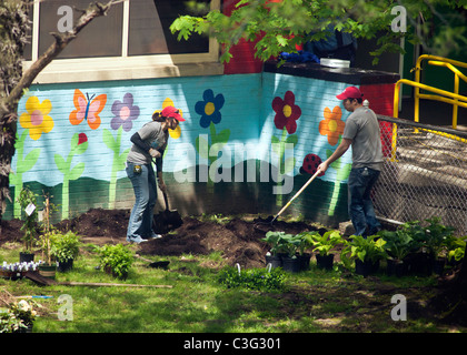 I volontari del paesaggio e per la creazione di un giardino nella parte anteriore di una scuola pubblica di New York Foto Stock