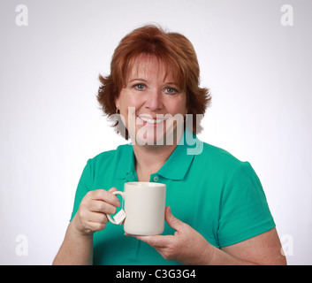 Attraente, sorridente di mezza età donna americana tenendo una tazza di tè, sfondo bianco studio shot, Aprile 20, 2011 © KAndriotis Foto Stock