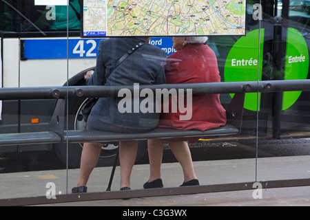 Donne anziane chat in attesa per il bus a Parigi, Francia Foto Stock