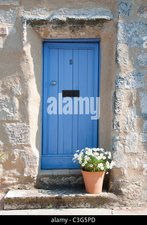 Un dipinto di blu porta e fiori in un vaso al di fuori di una casa in Dordogne, Francia Europa UE Foto Stock