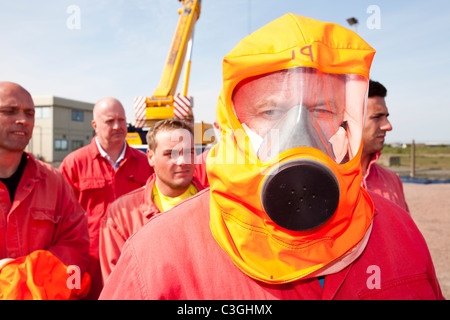 Lavoratori nell'industria offshore pratica la fuga da una camera di fumo come parte di un settore in corso di formazione, Foto Stock