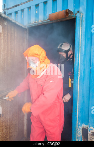 Lavoratori nell'industria offshore pratica la fuga da una camera di fumo come parte di un settore in corso di formazione, Foto Stock