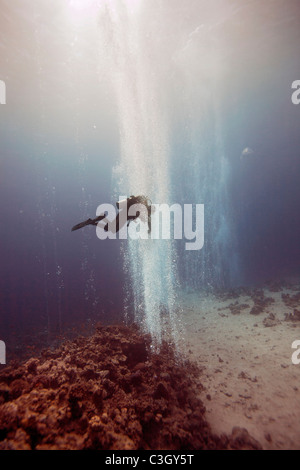 Un subacqueo nuota attraverso una cortina di bolle al Canyon. Mar Rosso, Dahab, Egitto Foto Stock