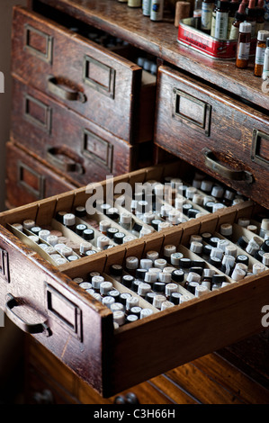 Bottiglie di medicinale omeopatico pillole in un assorbimento di legno Foto Stock