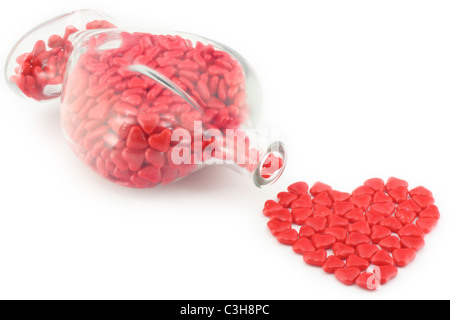 Bottiglia di San Valentino caramelle sparse in un cuore Il design sagomato. Foto Stock