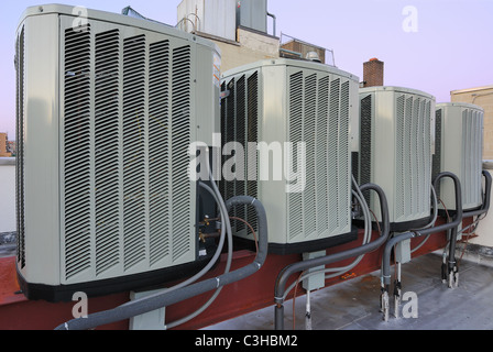 Una fila di unità di condizionamento dell'aria su un tetto. Foto Stock