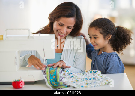 Madre e figlia (6-7) mediante cucitura a macchina Foto Stock