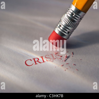 Studio shot di matita cancellare la parola crisi dal pezzo di carta Foto Stock