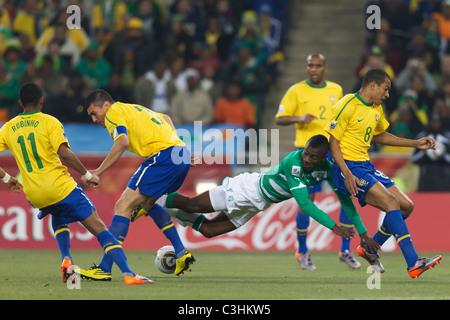 Salomon Kalou della Costa d'Avorio (c) viene sconvolto da Lucio del Brasile (3) durante la Coppa del Mondo FIFA 2010 Gruppo G partita di calcio. Foto Stock