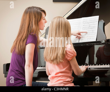 La ragazza (8-9) e madre suonare pianoforte Foto Stock