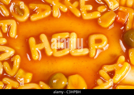 Alfabeto pasta sagomato formante la parola help in salsa di pomodoro Foto Stock