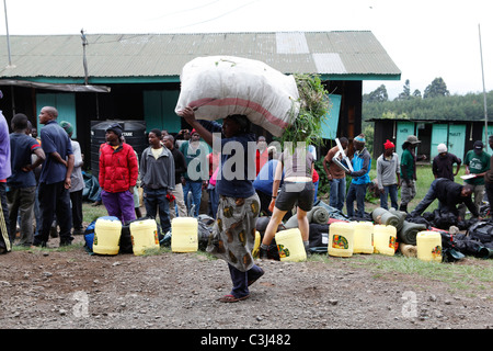 Aiutanti locali si stanno preparando il Kilimanjaro salita, alla Marangu Route a Mt. Kilimanjaro, Parco Nazionale del Kilimanjaro, Tanzania,Africa Foto Stock