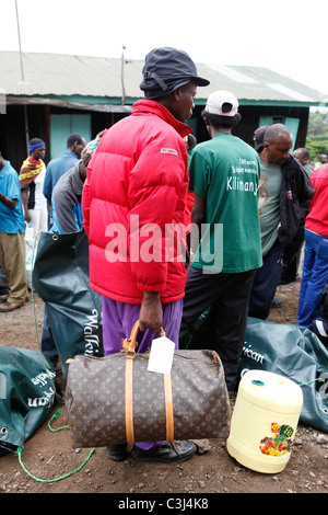 Aiutanti locali si stanno preparando il Kilimanjaro salita, alla Marangu Route a Mt. Kilimanjaro, Parco Nazionale del Kilimanjaro, Tanzania,Africa Foto Stock